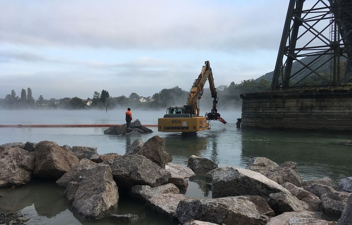 Bagger bei nebliger Stimmung im Wasser